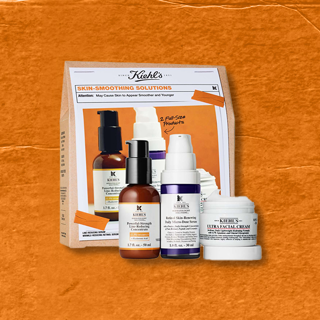 Immagine del cofanetto Kiehl’s Skin-Smoothing Solutions. Contiene Powerful-Strength Line-Reducing Concentrate, Retinol Skin-Renewing Daily Micro-Dose Serum e Ultra Facial Cream. Sfondo arancione con texture carta.