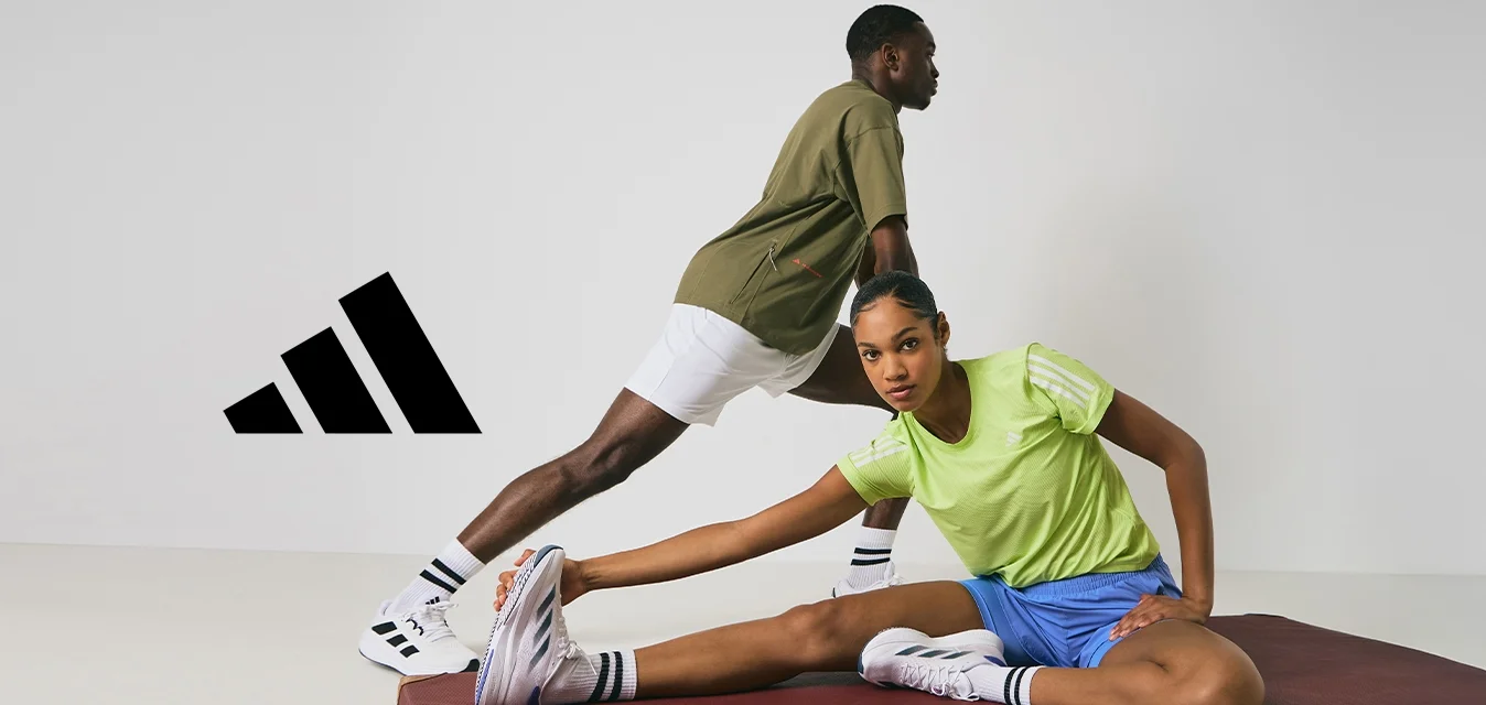 Due persone in abbigliamento sportivo si allungano su un tappetino per esercizi color bordeaux contro uno sfondo bianco.