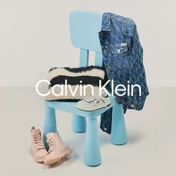 Sedia blu con maglione a righe bianco e nero, giacca di jeans appesa allo schienale, scarpe bianche per bambini sulla seduta e stivali rosa sul pavimento.