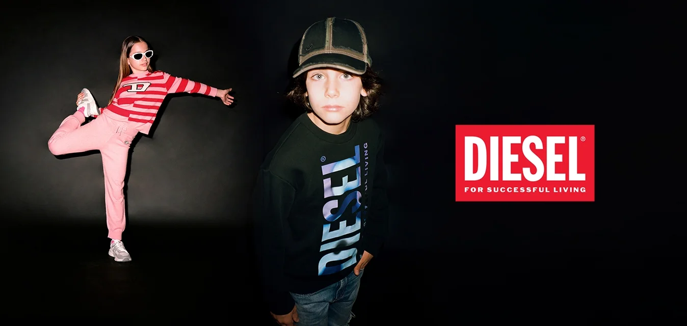 Una ragazza indossa un crop top a righe rosse e pantaloni jogger rosa con scarpe da ginnastica bianche. Un ragazzo in un felpa Diesel nera si trova vicino, guardando verso la macchina fotografica.