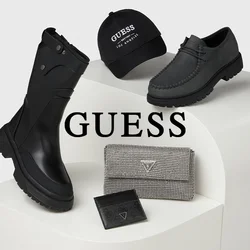 Stivali neri impermeabili, scarpe in pelle grigia, cappello nero con logo e portafoglio a fantasie esposti su un piedistallo curvo bianco.