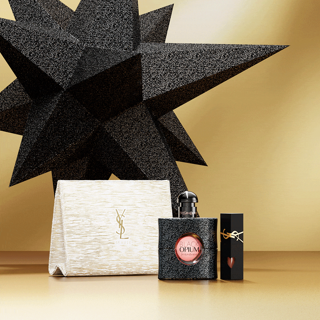 Prodotti YSL Beauté, inclusi il profumo Black Opium, un rossetto nero e una pochette YSL bianca, sono esposti su uno sfondo dorato con una stella nera scintillante.