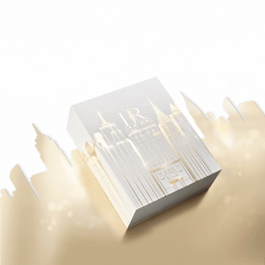 Il lussuoso calendario dell'avvento bianco e oro di Helena Rubinstein, su sfondo bianco,aperto con tutti i regali inclusi esposti davanti a lui