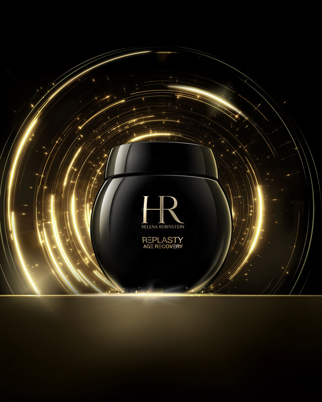 Il barattolo di crema Age Recovery Night è presentato su una superficie dorata con giochi di luce dorati scintillanti su uno sfondo scuro, sottolineando un'estetica premium.