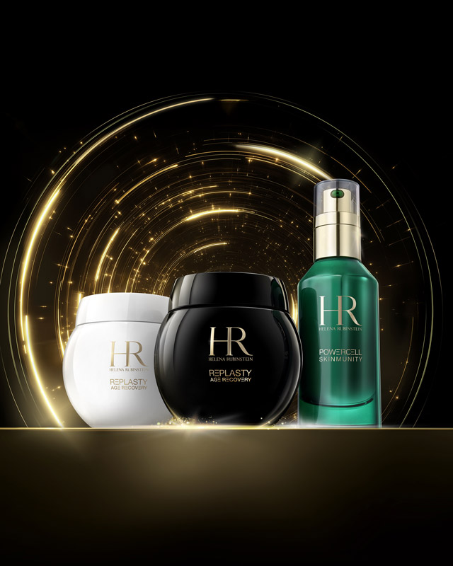 Gli iconi HR (Duo Replasty e Powercell Serum) presentati su una superficie dorata con giochi di luce dorati scintillanti su uno sfondo scuro, sottolineano un'estetica di alta gamma.