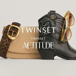 Stivale da cowboy in pelle nera con cuciture bianche, borsa beige con tracolla a stampa leopardata e occhiali da sole con lenti colorate di giallo appoggiati sullo stivale.