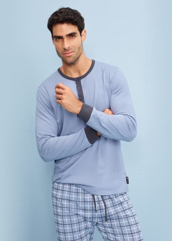 Modello indossa pigiama color avio  maniche lunghe con pantaloni stampati. Scopri i pigiami!