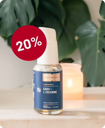 alt="Flacone di spray liposomiale Quicksilver Scientific GABA + L-Teanina su un piano di lavoro con una candela accesa e un distintivo rosso di sconto del «20%».»