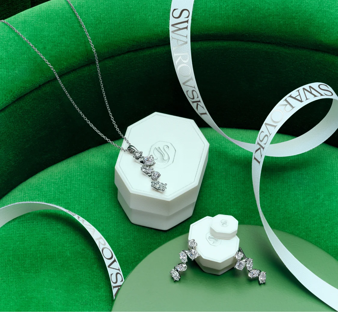 Gioielli Swarovski Created Diamonds e confezioni regalo bianche su sfondo verde