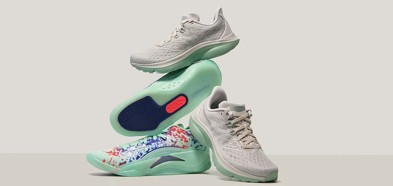 Scarpe sportive grigio chiaro con tomaia in rete testurizzata, suola verde chiaro e un motivo astratto multicolore sulla parte inferiore della scarpa.