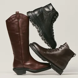 Tre stivali in pelle impilati: uno stivale da equitazione marrone alto, uno stivale da trekking nero e uno stivale alla caviglia marrone scuro.