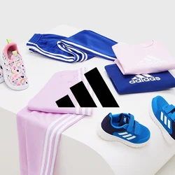 Abbigliamento Adidas in esposizione: maglietta rosa, pantaloni blu, varie scarpe e un paio di slip-on con fantasia. I materiali sono tessuto e gomma; i colori sono vivaci.