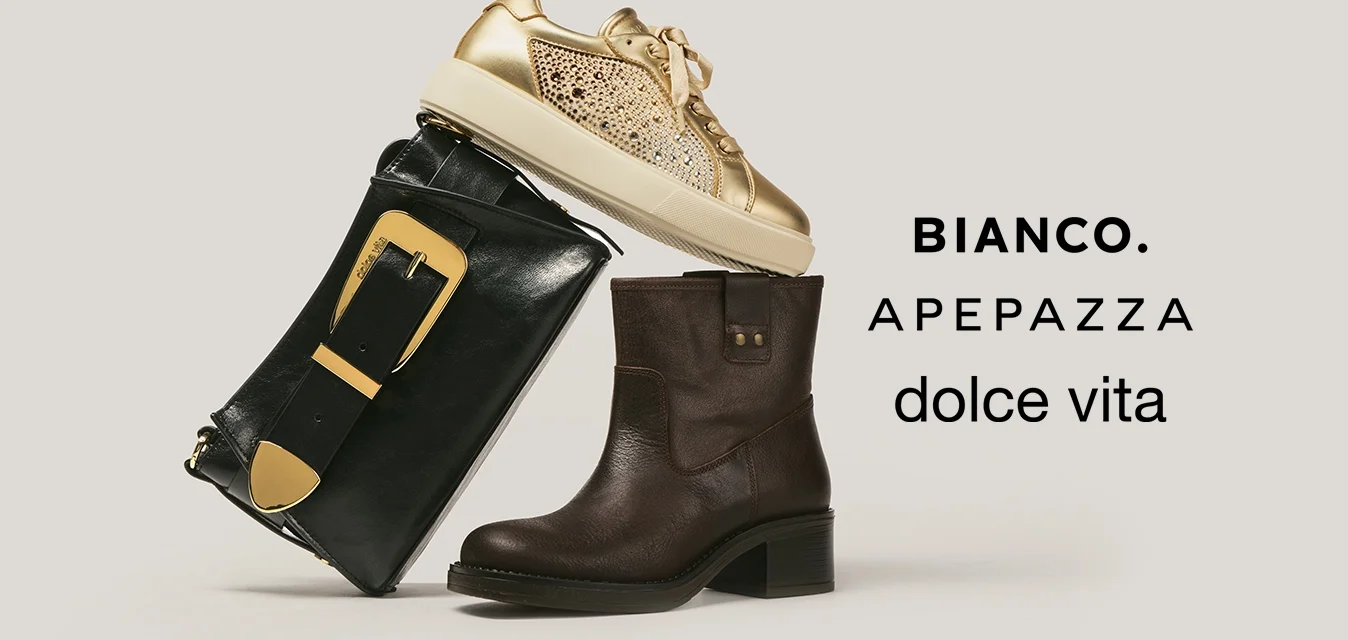 Pochette in pelle nera con fibbia dorata appoggiata a uno stivaletto marrone, sormontata da una sneaker glitterata dorata su sfondo beige.