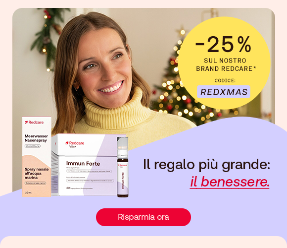 &bdquo;Donna sorridente con maglione giallo davanti all&rsquo;albero di Natale. A sinistra i prodotti Redcare Spray nasale all&rsquo;acqua marina e Immun Forte. Bollino giallo con testo: &lsquo;-25% sul nostro brand Redcare, codice REDXMAS&rsquo;. Testo: &lsquo;Il regalo pi&ugrave; grande: il benessere.&rsquo; Pulsante rosso: Risparmia ora.&ldquo;