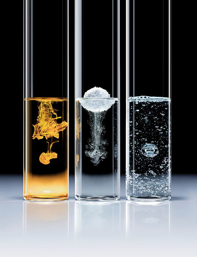 Tre provette da laboratorio allineate su sfondo nero. Ogni tubetto contiene una texture diversa che rappresenta i tre principi attivi chiave: una soluzione ambrata (Lipocatalyst TM), una texture bianca effervescente o polverosa (Hyalusculptors TM) e un liquido chiaro con bolle (acido glicirrizico). Questo illustra l'approccio scientifico e all'avanguardia della formula.