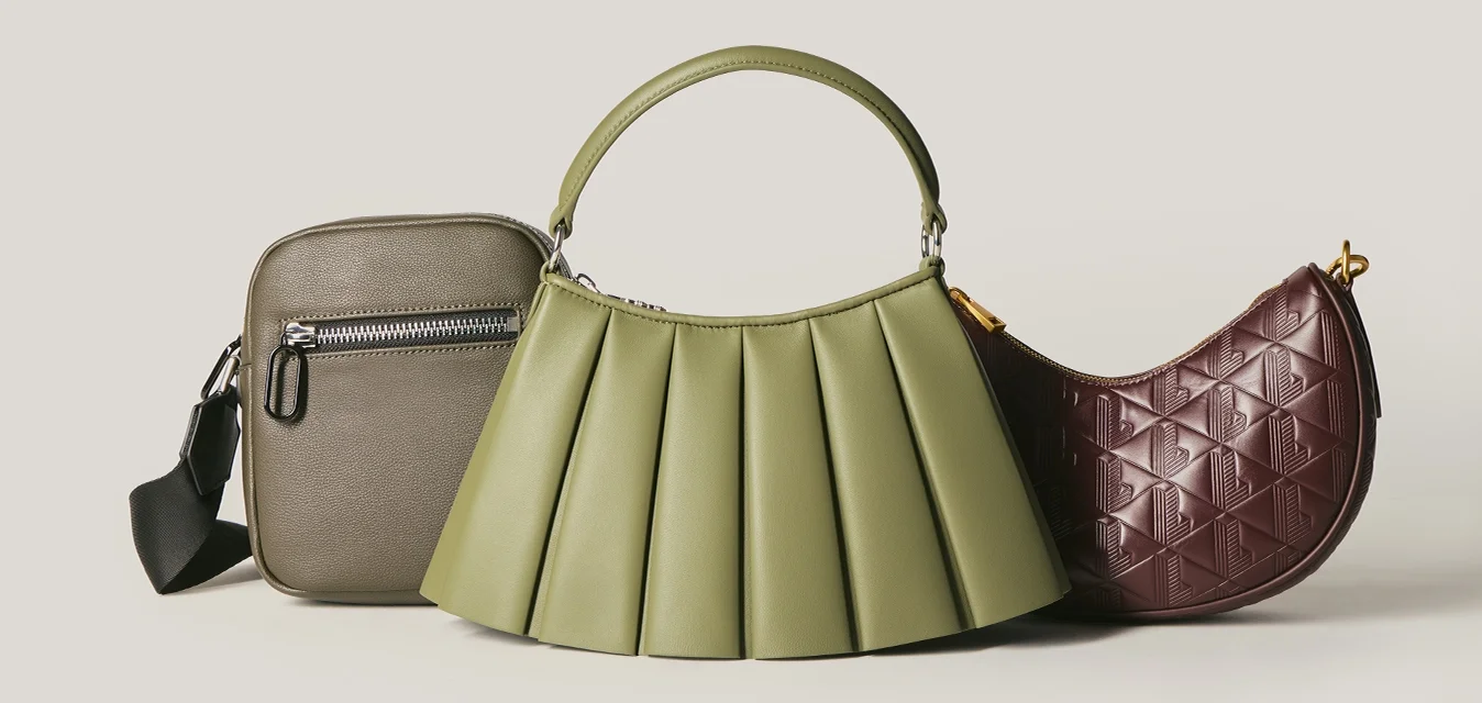 Tre borse alla moda in grigio, verde plissettato con manico e marrone trapuntato a forma di mezzaluna su uno sfondo neutro.