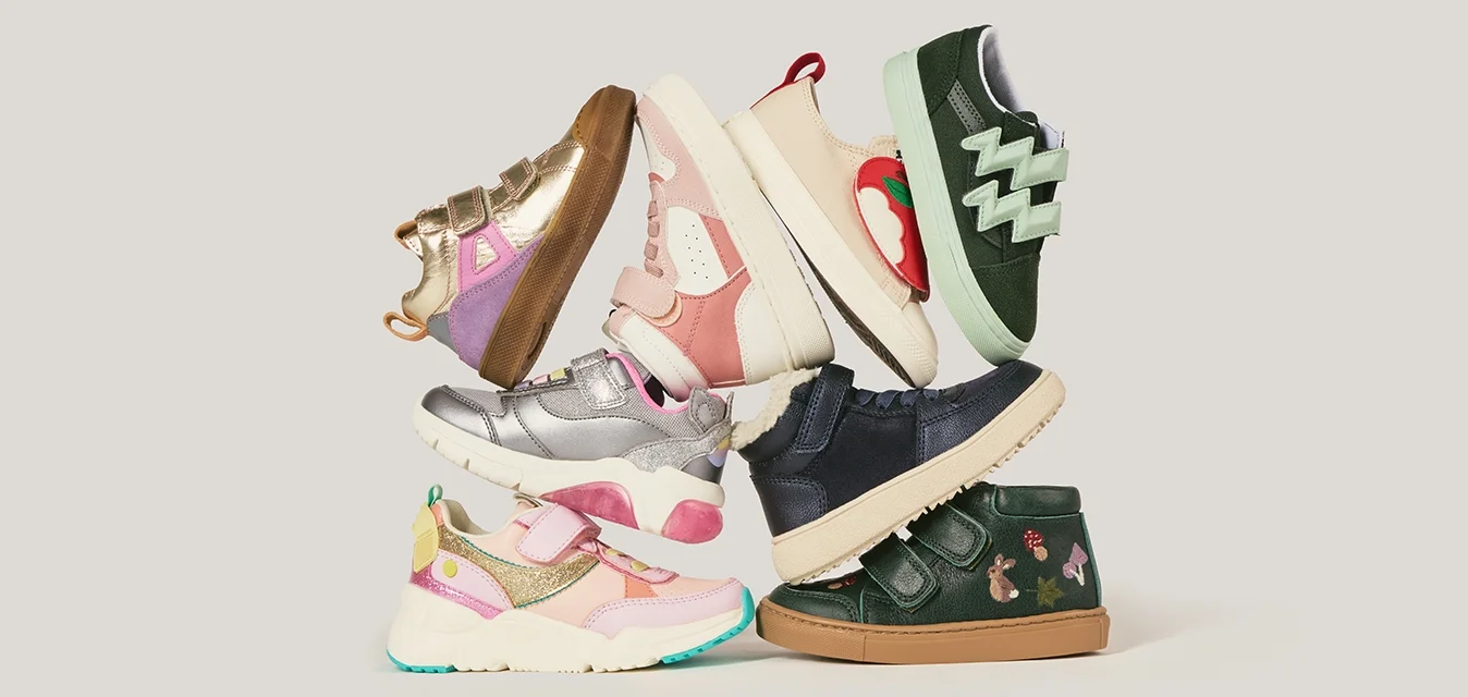 Collezione di scarpe per bambini variegate che presentano molteplici colori, materiali, texture e design, inclusi cinturini, motivi e accenti.