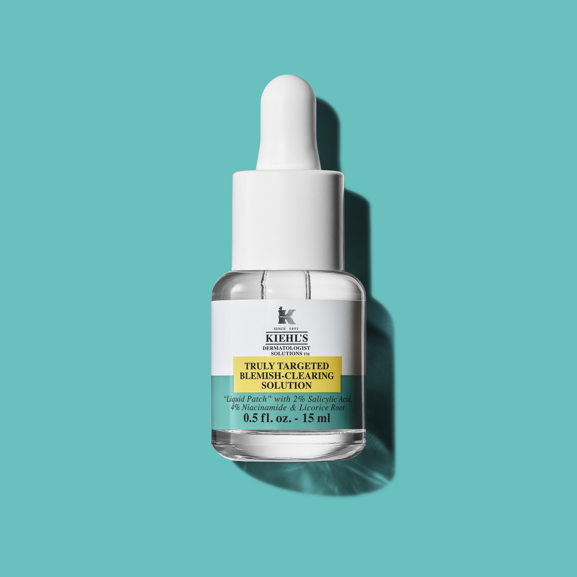Flacone in vetro con contagocce del trattamento localizzato Kiehl&rsquo;s Dermatologist Solutions &ldquo;Truly Targeted Blemish-Clearing Solution&rdquo; da 15 ml, su sfondo turchese. Il prodotto &egrave; mostrato come intervento mirato sulle imperfezioni.