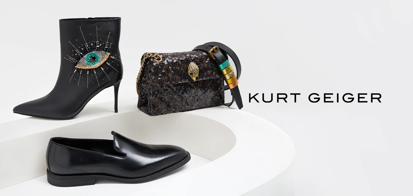 Stivaletto alla caviglia con tacco alto in pelle nera con motivo a occhio, mocassino in pelle nera e borsa nera con paillettes e dettagli colorati su esposizione curva bianca.