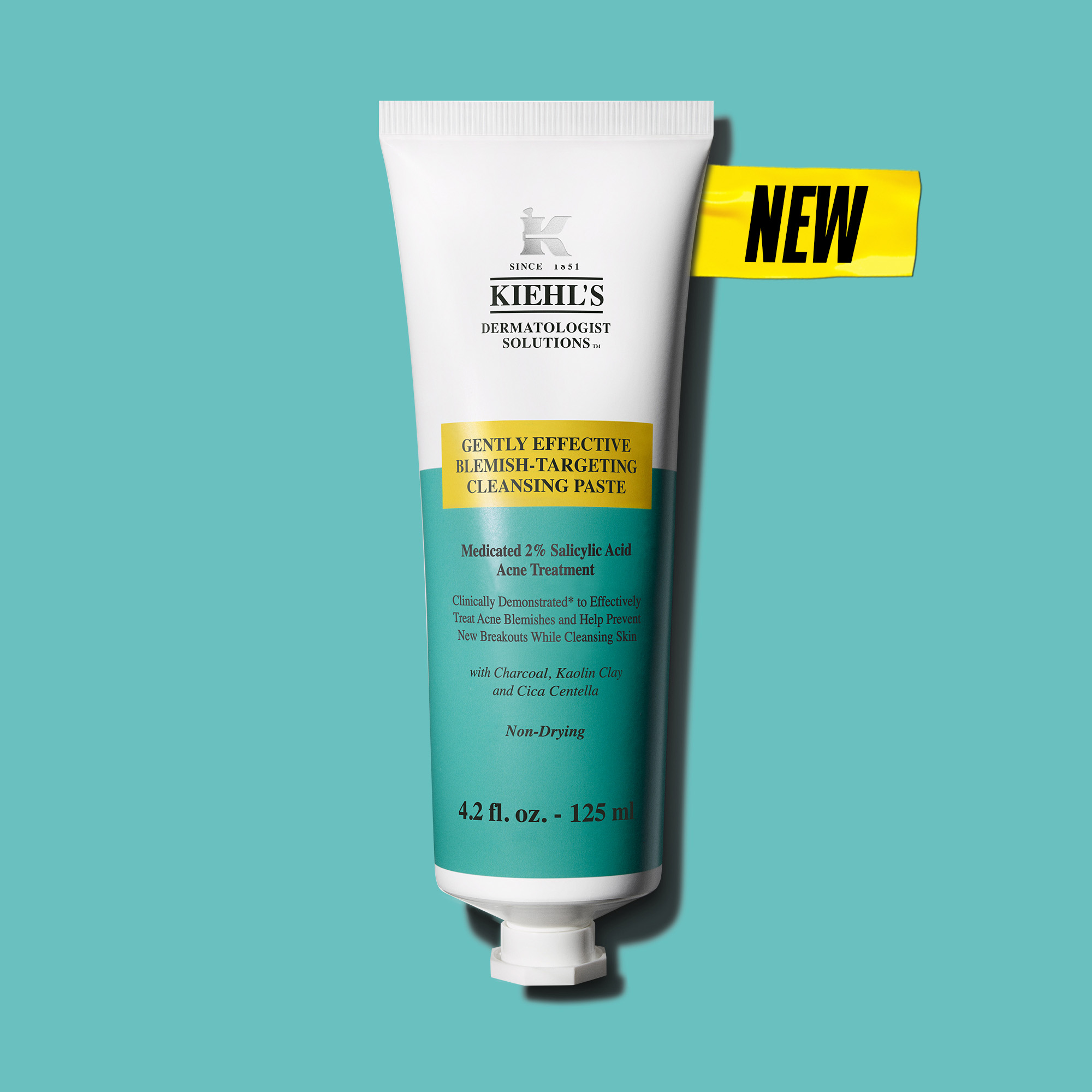 Tubo del nuovo detergente viso Kiehl&rsquo;s Dermatologist Solutions &ldquo;Gently Effective Blemish-Targeting Cleansing Paste&rdquo; da 125 ml, su sfondo turchese, con tappo bianco. Il prodotto &egrave; mostrato frontalmente come primo step della routine anti-acne.