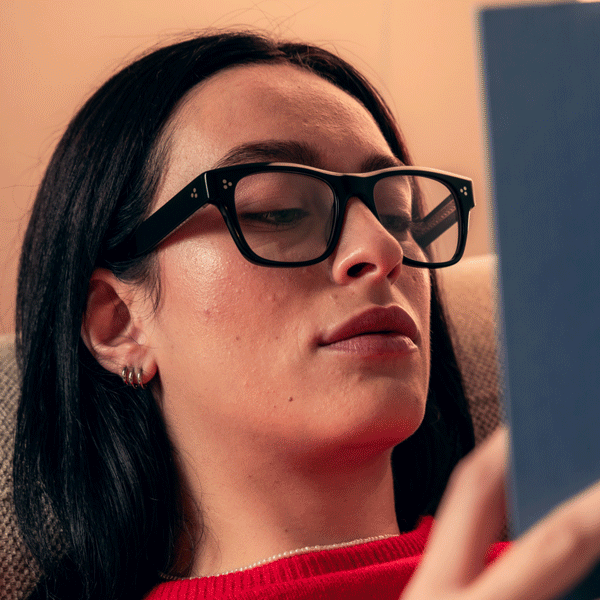 Persona che indossa occhiali da lettura di design