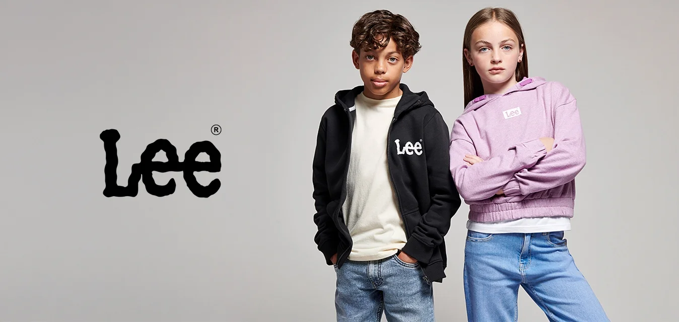 Due bambini in piedi con sicurezza, uno indossa una giacca nera Lee e l'altro un hoodie lilla Lee, entrambi con dei jeans su uno sfondo semplice.