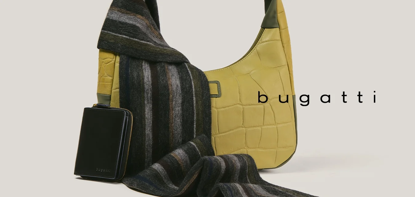 Borsa texturizzata gialla con accenti verdi, sciarpa a righe nere appoggiata sopra e piccolo portafoglio con cerniera nero accanto su sfondo neutro.