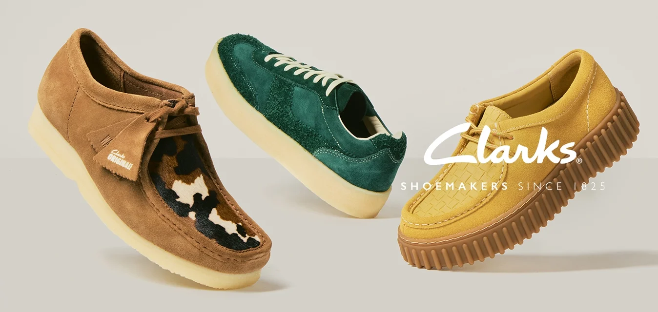 Tre scarpe casual: una marrone con dettagli in pelliccia, una in suede verde con lacci bianchi, e una gialla con suola testurizzata, esposte su uno sfondo chiaro e semplice.