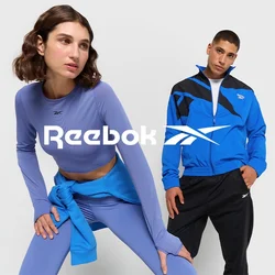 Abbigliamento sportivo con una maglietta a maniche lunghe lavanda e leggings blu, insieme a una giacca blu con dettagli neri e pantaloni neri.