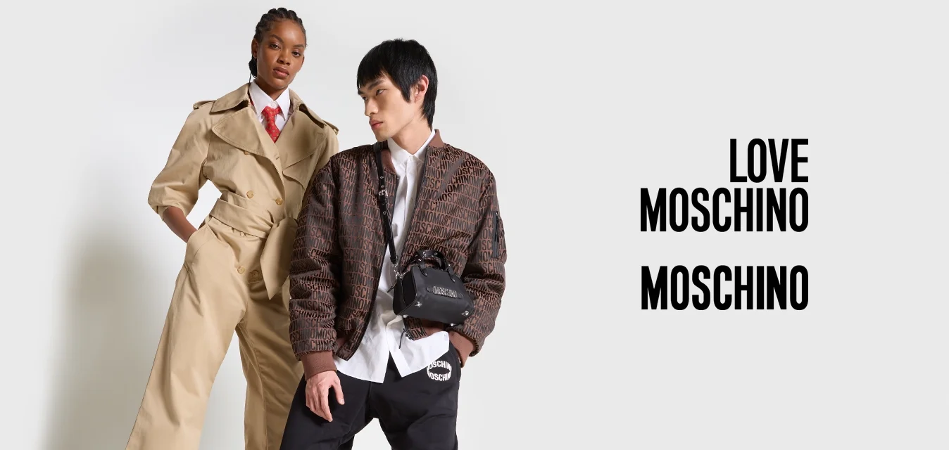 Trench beige su una persona, abbinato a una camicia bianca e una cravatta rossa. Un'altra persona indossa una giacca a fantasia, pantaloni neri e sneaker.