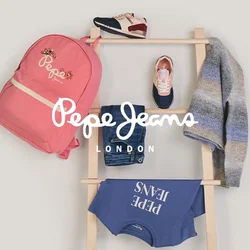 Scala di legno con uno zaino rosa, jeans blu, felpa blu navy, maglione grigio a righe e due paia di scarpe da ginnastica appoggiati contro una parete bianca.