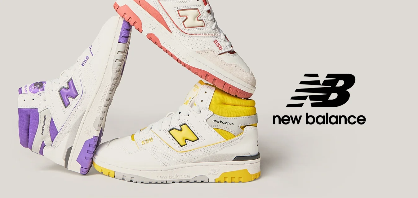Tre paia di sneakers New Balance bianche con accenti viola, rosso e giallo, disposte a formare un triangolo su uno sfondo chiaro.