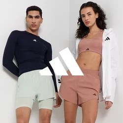 Due modelle indossano abbigliamento sportivo: una maglia a maniche lunghe blu navy, pantaloni corti mint, e un crop top rosa chiaro abbinato a pantaloni corti marroni, con una giacca bianca.