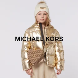 Giacca imbottita dorata, cappotto interno nero, gonna plissettata beige, borsa a tracolla marrone con logo e scarpe nere con dettagli dorati.