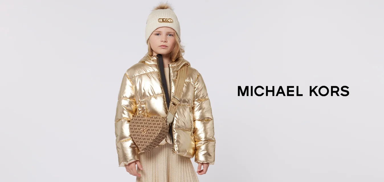 Giacca imbottita dorata, cappotto interno nero, gonna plissettata beige, borsa a tracolla marrone con logo e scarpe nere con dettagli dorati.