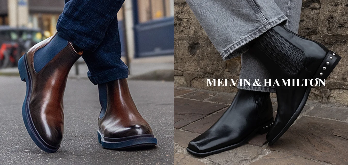 Stivale alla caviglia in pelle marrone con pannello elastico blu, abbinato a jeans scuri; stivale Chelsea in pelle nera con lato a coste e borchie, abbinato a jeans grigi.