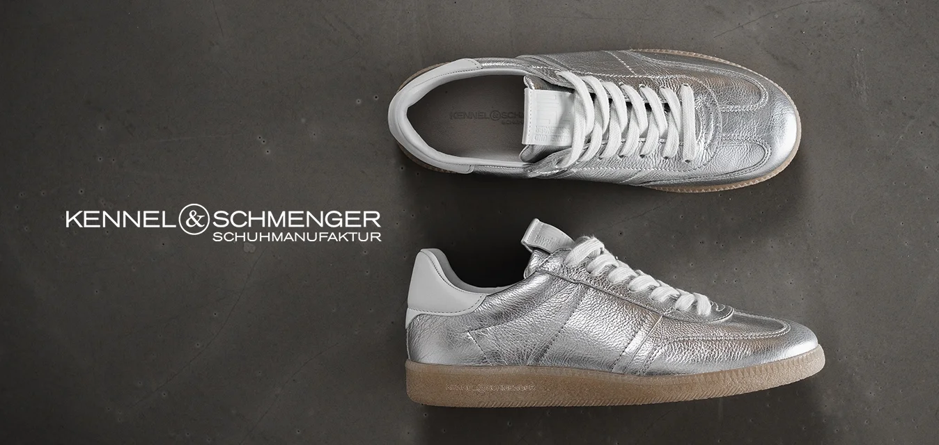 Sneakers argentati metallici con tomaia testurizzata, lacci bianchi e suola in gomma beige, caratterizzati da elementi di design minimalisti e dettagli di cucitura.