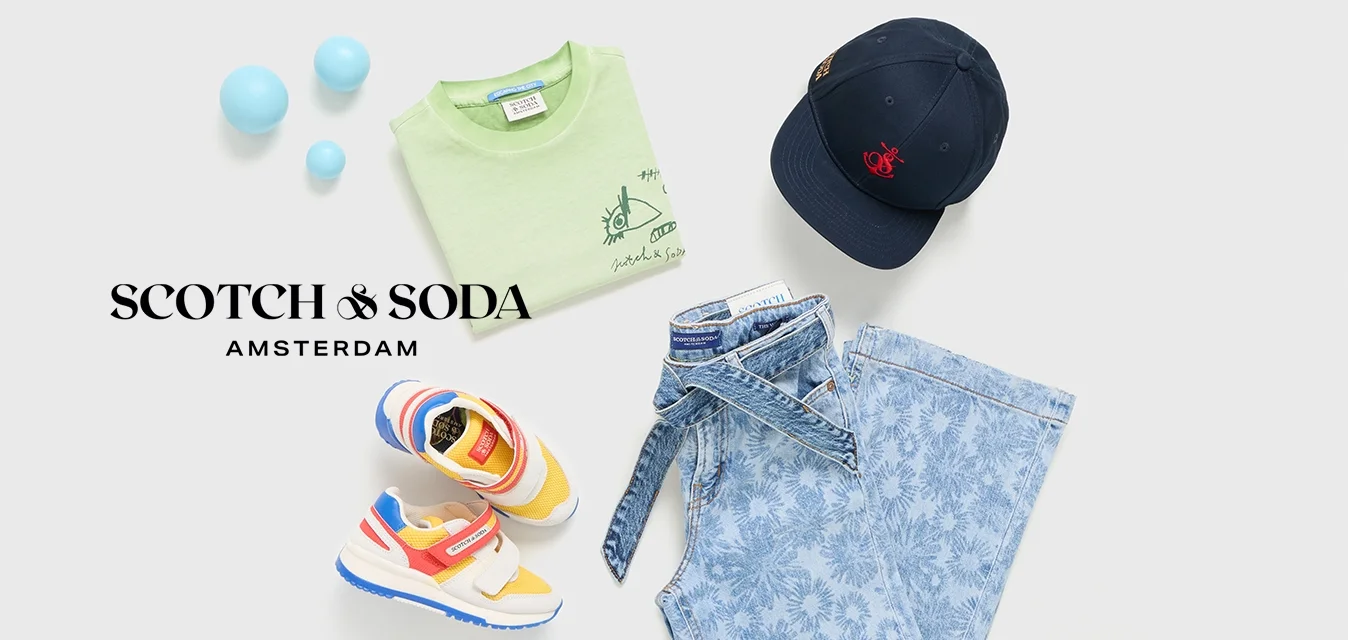 T-shirt verde in cotone, shorts in denim floreali blu chiaro, sneakers gialle e rosse, cappellino blu navy con emblema e palle colorate.