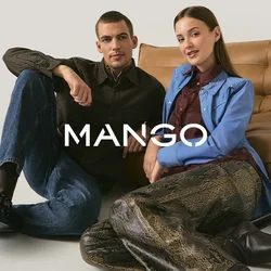 Giovane uomo e donna seduti sul pavimento appoggiati a un divano in pelle color cuoio, vestiti con abiti casual e alla moda contro uno sfondo semplice.