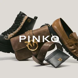 Stivaletto da combattimento foderato in pelliccia nera, borsa a tracolla in pelle marrone con emblema dorato, mocassino marrone, cintura marrone e piccolo portafoglio nero su sfondo chiaro.