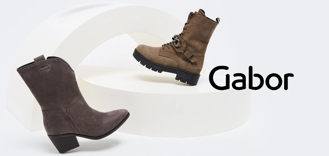 Tre paia di stivaletti esposti su una piattaforma curva bianca: stivaletti alla caviglia in suede grigio, stivaletti marroni con lacci e stivaletti taupe con tacco a blocco.