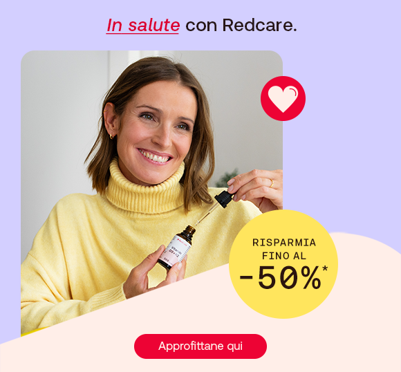 Una donna con maglione giallo chiaro sorride mentre tiene una boccetta di integratore con contagocce. In alto il testo: &ldquo;In salute con Redcare&rdquo;, con &ldquo;In salute&rdquo; in rosso corsivo. A destra un bollino giallo con scritto: &ldquo;Risparmia fino al -50%&rdquo;. In basso un pulsante rosso: &ldquo;Approfittane qui&rdquo;.