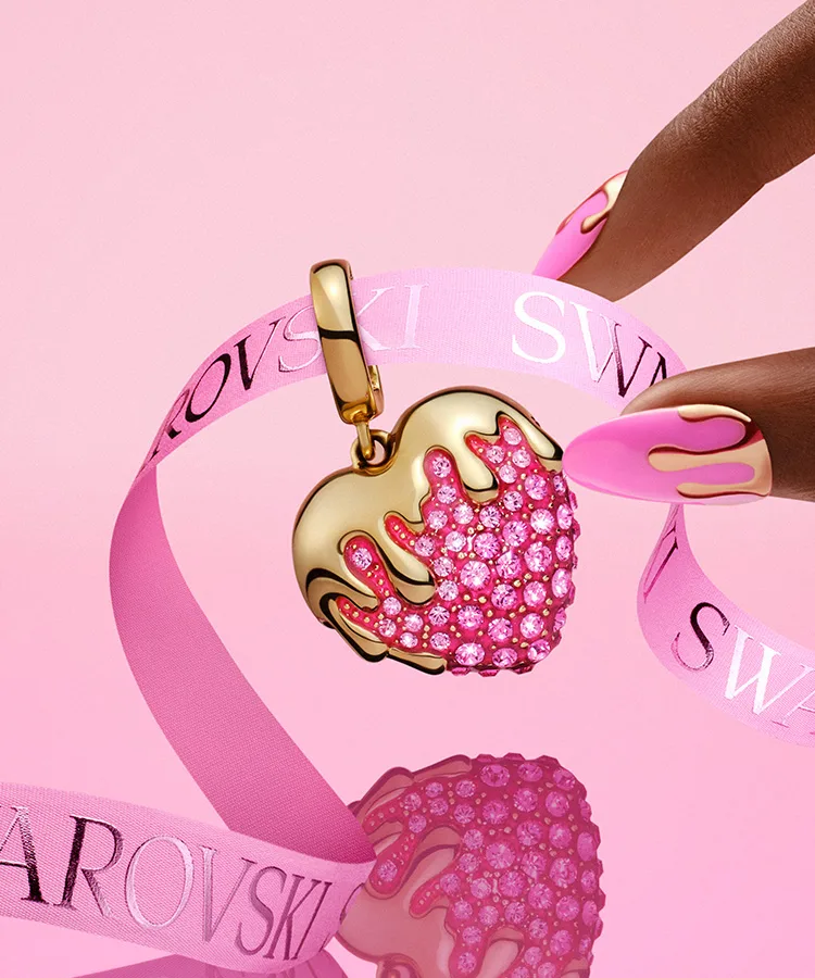 Dita che stanno per prendere un charm Swarovski a forma di fragola