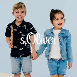 Due bambini in piedi uno accanto all'altro. Il ragazzo indossa una maglietta nera con motivi bianchi, pantaloni corti di denim e scarpe da ginnastica. La ragazza indossa una giacca azzurra, una maglietta bianca e pantaloni corti di denim.