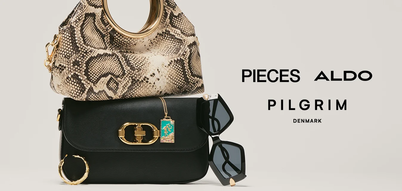 Due borse impilate, con una borsa in pelle di serpente sopra e una nera sotto, accompagnate da occhiali da sole neri e orecchini a cerchio dorati.