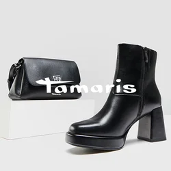 Stivaletti neri in pelle con tacco spesso, una piccola borsa nera, e mocassini lucidi con un dettaglio a catena, tutti su uno sfondo chiaro.