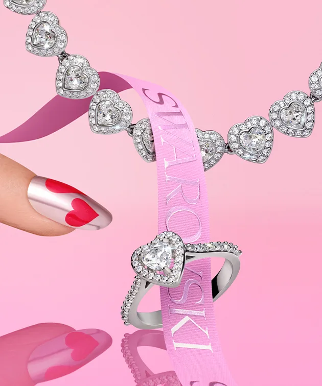 Gioiello a forma di cuore su sfondo rosa con nastro rosa