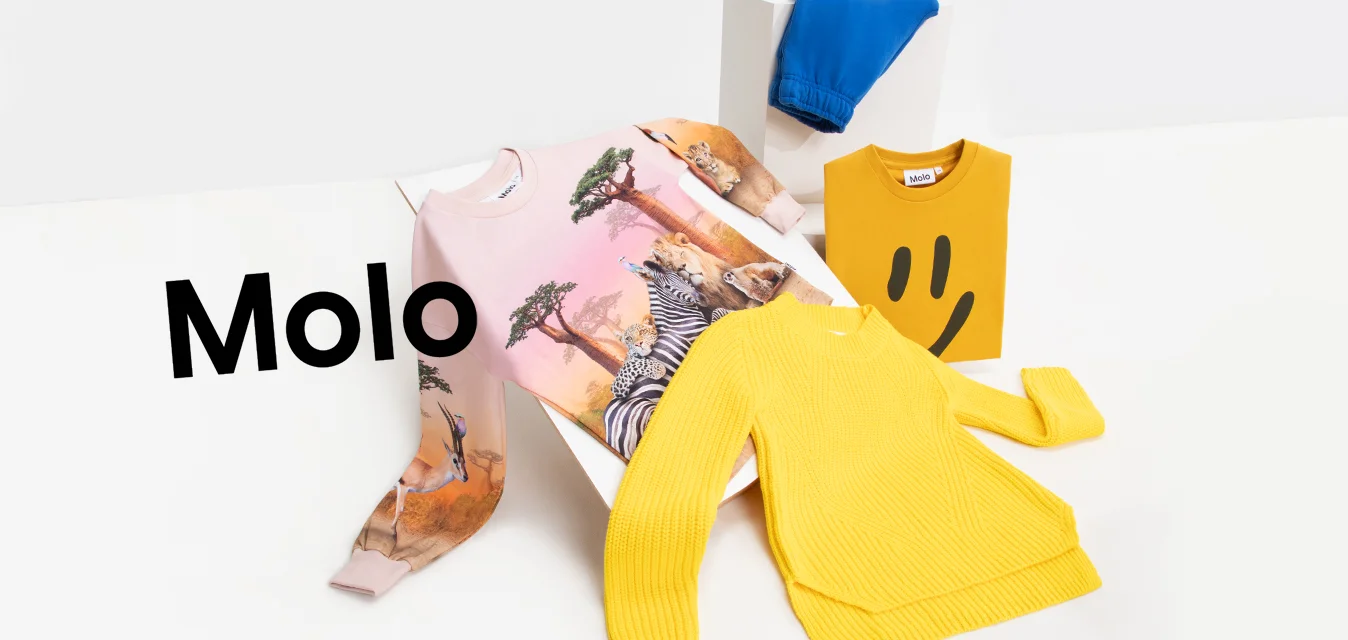 Tre articoli di abbigliamento: una felpa rosa con stampa animale, un maglione giallo a coste e un paio di pantaloni blu. Tutti posti su uno sfondo bianco.