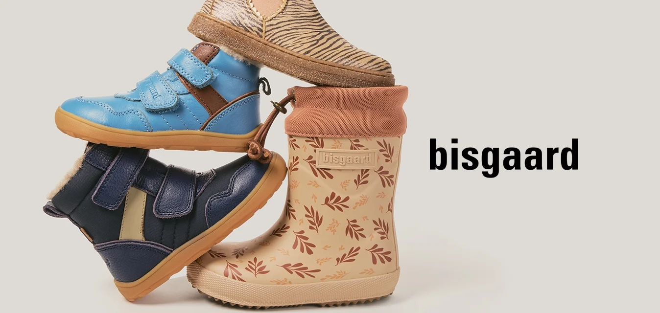 Scarpe per bambini impilate: stivale impermeabile beige con motivo a foglia, scarpe da ginnastica blu con velcro, scarpe da ginnastica navy con velcro e stivaletto alla caviglia zebra-print beige.