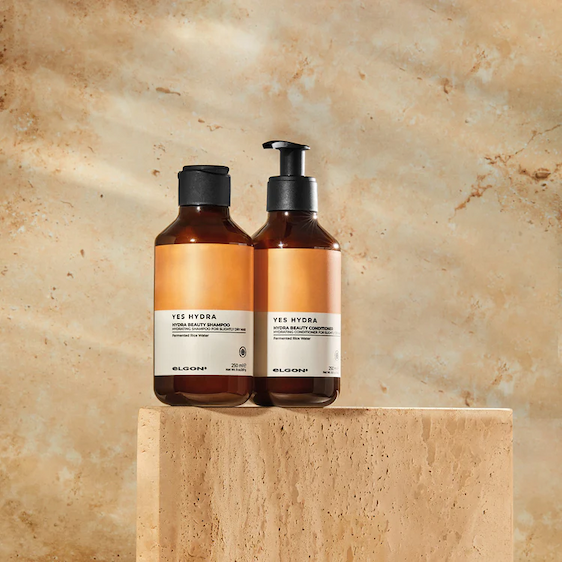 an image of a bottle of liquid sitting on a bed of petals